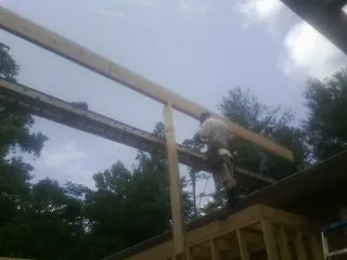Carpenter setting a ridge beam over a new addition frame — Ice Dam Removal by Roofing Brothers in Tallmadge