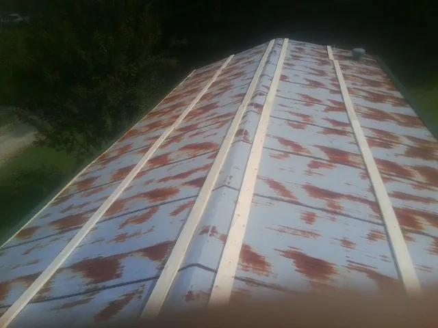 Rusted metal roof panels with new wood purlins before replacement — Storm Damage Roof Repair in Tallmadge by Roofing Brothers