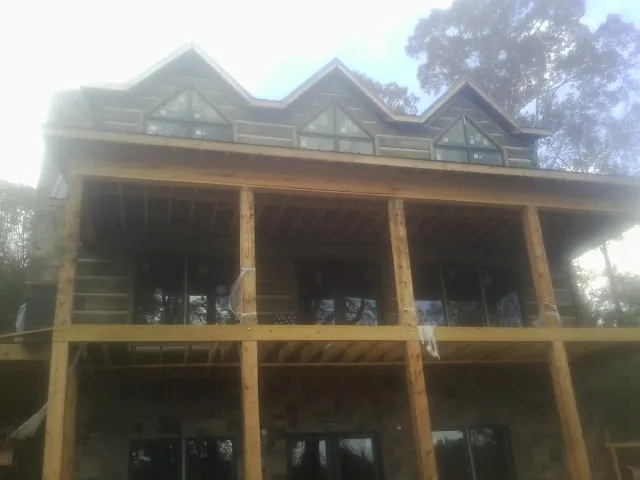 Dormers and porch framing on a large log home under construction — Roof Coating work by our crew in Tallmadge