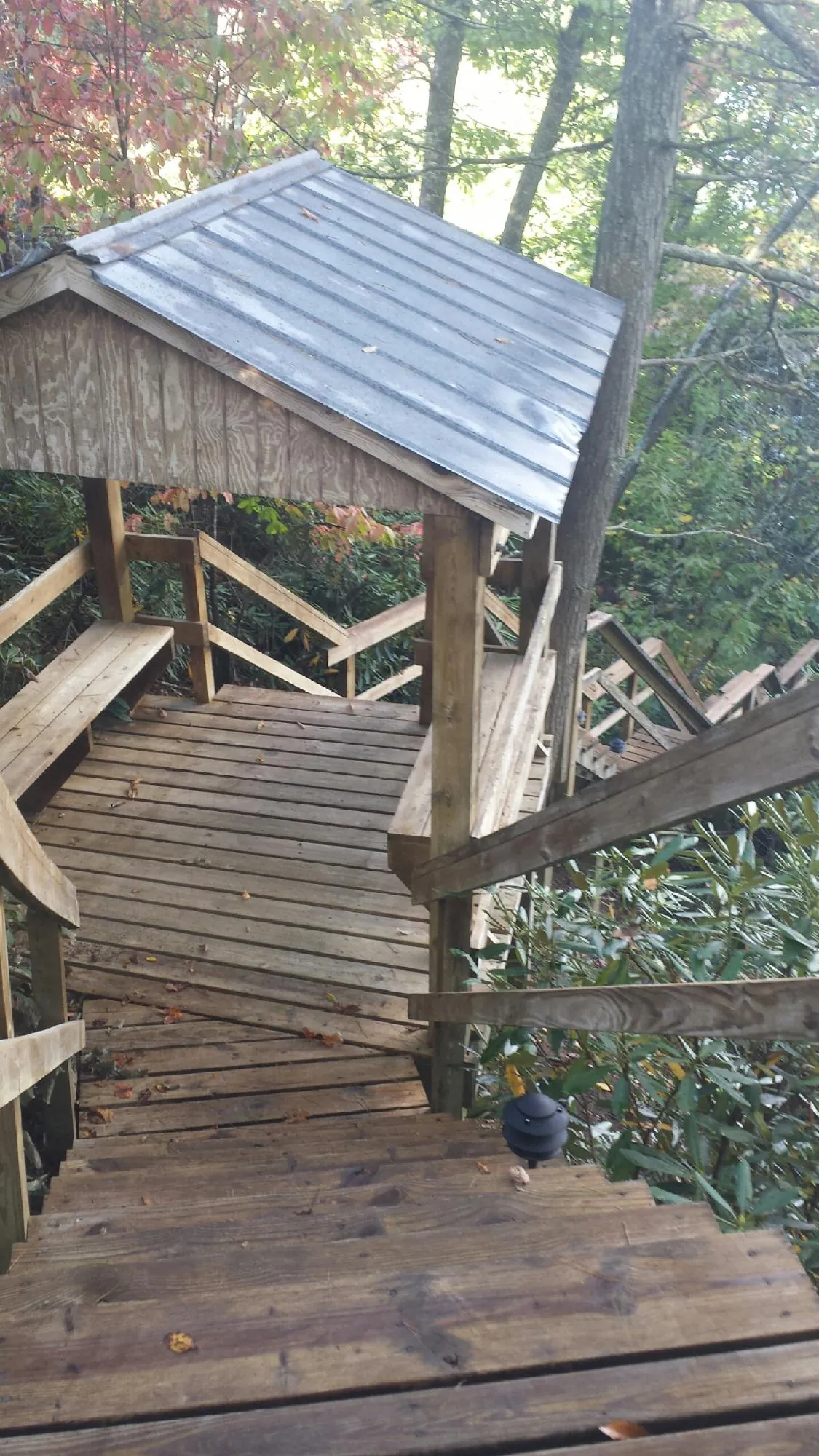 Metal roofed shelter over wooden steps on a wooded walkway — Skylight Repair & Installation work by our crew in Tallmadge